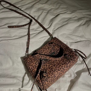 Leopard väska 🤎 - Asball crossbody väska med leopardmönster! Väskan är köpt på Nelly för två år sen och endast använd enstaka gånger sen dess. Den rymmer relativt mycket och har dessutom ett innerfack och litet ytterfack. Säljer för att den inte kommer till användning 💓💓