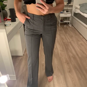 Kostymbyxor  - Ett par grå kostymbyxor från NAKD, använda någon enstaka gång, säljes på grund av något stor storlek! Sömmar framtill och slits vid ankeln. 