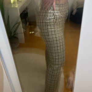 Rutiga kostymbyxor från YARGICI - Rutiga kostymbyxor i beige/ brun med spänne i midjan. SUPERFINA nu till hösten antingen som vardags eller att klä upp!!! 100% polyester, långa i benen, storlek 38. Jagfullkomligt älskar dessa men har tyvärr växt ur. Köpt på zalando för ca 800kr