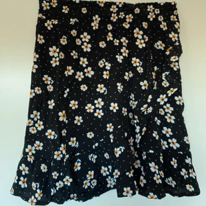 Blommig kjol med volang - Supersöt blommig kjol med volang som går i omlott samt längst ner på kjolen. Storlek XS. Köparen står för frakt (66kr spårbar)