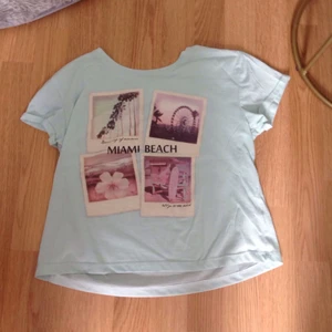 Tröja - En tröja i färgen turkos med text "Miami Beach" och fyra bilder. Anävänder ej längre och därför jag säljer den. I bra material!