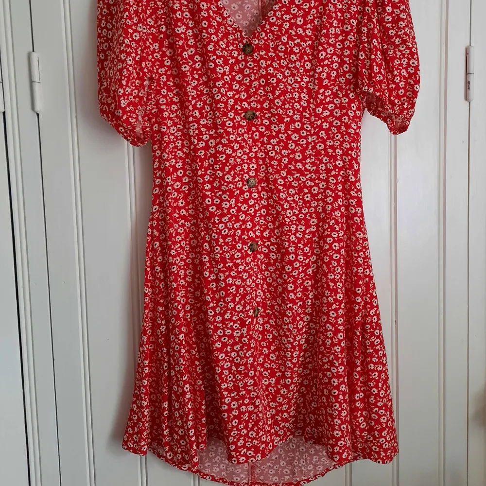 Jättefin röd klänning med vita små blommor. Köpt på HM, men finns inte längre kvar att köpa på hemsidan. Använd max 3 gånger, nyskick 🌸. Klänningar.