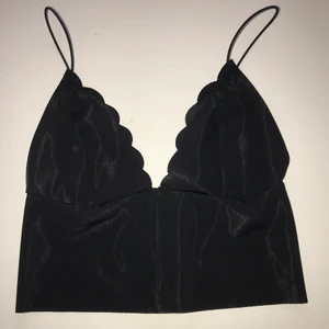 Svart topp med bh-stuk, strl. S - En svart tunn topp som har en bh-funktion. Bh-knäppe i ryggen och tunna axelband. 