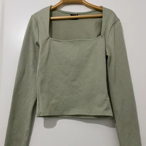 Gina tricot ”nella top” strl XS - Det är en långärmad topp med figurnära passform. Toppen är pistasch grön och ribbad samt har en fyrkantig halsringning. Använd en gång och är i bra skick. Ordinarie pris: 199kr. Kan mötas upp i Stockholm eller står köparen för frakten. 