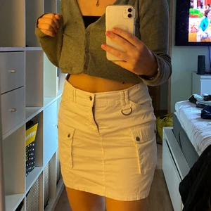 Vit kjol med detaljer  - En fin vit kjol, med detaljer, knappt använd. Storleken är M, men passar även L. Lite stor i midjan för M. Pris exkl. frakt som köpare betalar.