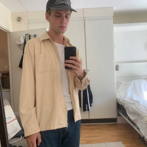 Ljusbeige overshirt i Manchester  - Ljusbeige overshirt i Manchester. Knappt använd. Storlek XS men är stor i storleken