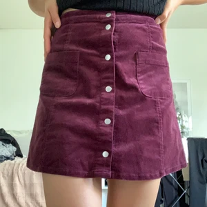 Vinröd trikåkjol i Manchester  - Trikåkjol med fickor fram och bak från Gina Tricot. 
