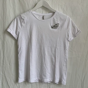 T-shirt med fastsydd brosch! - Vit T-shirt med fastsydd brosch från Stradivarius. Är lite mindre i storlek så är mer som en XS-S. Har knappt använt den då den var lite liten för mig. 