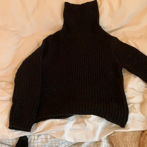 Stickad polo - En svart stickad polo men hög krage eller möjligt att vika ner. Lite nopprig på armarna men annars i gott skick! 