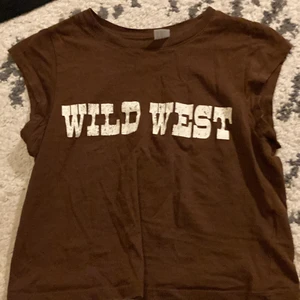 Brun tröja från HM storlek XS❤️ - Fin brun topp från HM! Tryck: Wild west. Använd typ 3 gånger så knappt, mjukt material👌 kontakta mig för billigare pris! Fick den för 140 kr på HM