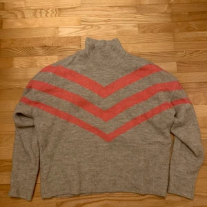 Stickad tröja - En beige stickad tröja från Lindex i storlek m med rosa ränder. Den har en liten krage och är oversized.