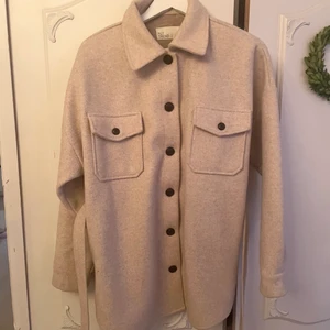 Skjortjacka NLY trend storlek 36 - Beige jacka med tillhörande skärp. Använd sparsamt en säsong. Bilden från Nellys hemsida är något vitare i färgen men visar hur den sitter på. 
