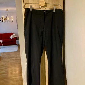 Utsvängda Kostymbyxor med pressveck - ▪️Kostymbyxor Weekday Storlek: 36 Modell: utsvängda, Korta ben Material: 68% polyester, 32% viscos Skick: endast provade av mig, aldrig använda