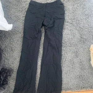 Svart raka kostymbyxor - Svarta raka kostymbyxor som är förstora för mig som ni ser på bilden vilket inte gör dem rättvist.  Väldigt långa så passar nog någon upp till minst 175 cm och kortare. Står inte storlek men skulle chansa på M. Midwaist