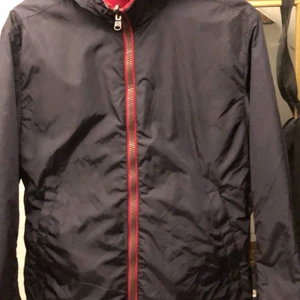 Colmar regnjacka  - En tunnare Colmarjacka, perfekt vid en regnig sommardag eller en joggingtur. Plagget är använt försiktigt ca 4 gånger och har inga defekter. Jackan är köpt på ”myclassicio” för 2000 kr och säljes för 1350 eller högst bud. Original tags och QRkod finns. Jackan kan även bäras ut och in och är då helt röd. Skriv om fler bilder önskas 