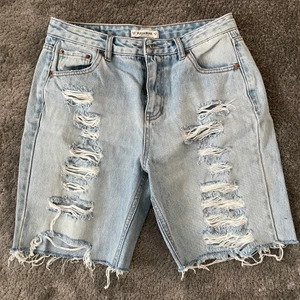 Jeans shorts från pull&bear - Jeans shorts i mom-jeans modell med slitningar. Det var ett par jeans men jag klippte av dem till shorts. Skulle säga att de är mer ljusblå än dem framhävs som. Storlek 36. Använda men i bra skick. Köparen står för frakt.