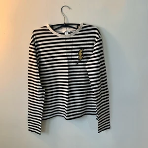 Randig tröja  - Långärmad tröja från h&m, svart och vit randig med en blixt. Tröjan är använd men utan slitage och fläckar. Pris är ink frakt