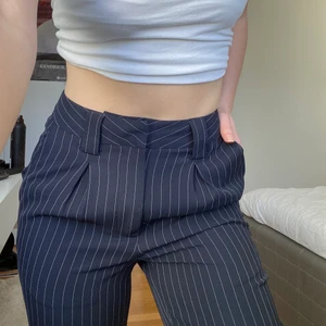 Kostymbyxor  - Marinblåa kostymbyxor med vita ränder från NA-KD. Storlek 32 men passar nog 34. Helt oanvända.