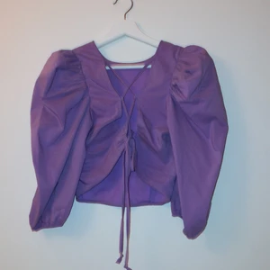Lila topp - Lila topp med fin snörning i ryggen. Använd endast en gång. Köpt för ca 300kr. Köparen står för leveransen och betalning sker via swish!💕