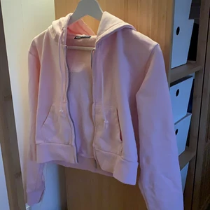 Brandy Melville Hoodie  - Oanvänd ljusrosa Brandy Melville (croppad) hoodie. Fin ljusrosa färg men för liten för mig. Storlek ”one size” men jag anser den vara XS-S (34-36). Säljer för 150 kr + frakt (ca 66 kr) 