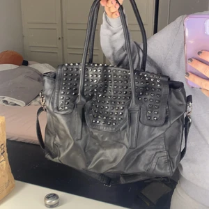 Väska med nitar - En svart väska med långa samt korta band och nitar. Så cool och fin. Väskan är lite större så prefekt som shopping väska! 220kr+frakt. Hör av dig vid frågor ellee flera bilder! 