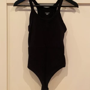 Svart ribbad stringbody med öppen rygg - Svart tjockt ribbad stringbody med öppen rygg. Aldrig använd 