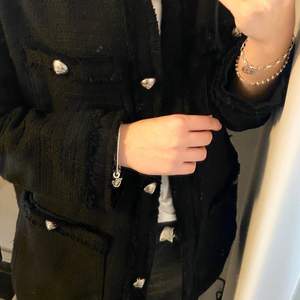 Svart blazer/jacka från H&M med textur & silverknappar. Aldrig använd med prislapp kvar. Nypris 499kr. Storlek S. Fräshar upp outfiten!! 