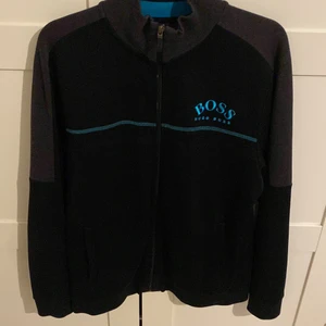 Hugo boss zip tjocktröja - Tröjan är i jättebra skick, knappt använd. Säljer pga att den är för liten. Köpt på NK för 1250. 