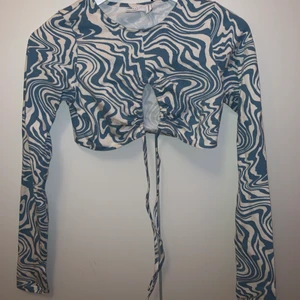 Topp långärmad croppad - Häftig långärmad crop-top med unik knytning där fram. Ärmarna har hål för tummarna✨ Köpt på asos.