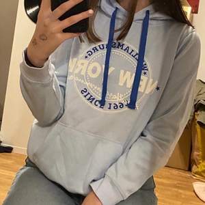 En ljusblå hoodie med tryck på framsidan 🥰