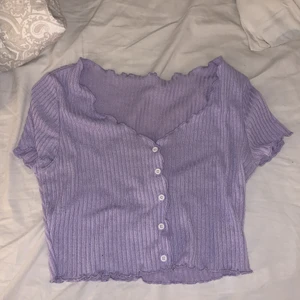 T-shirt från SHEIN  - En lila T-shirt med vita knappar i mitten från SHEIN i stolen M. Aldrig andvänd bara testad. 