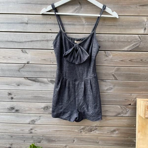 Söt byxdress  - En söt byxdress i marinblått/svart med rosett framtill, justerbara band samt små fickor. Köpt i USA, passar XS/S