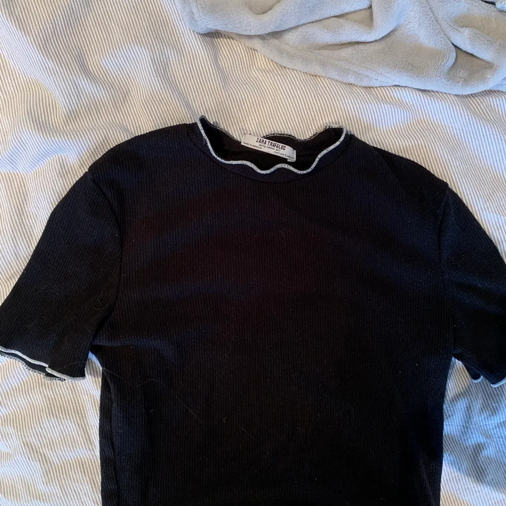 En svart t-shirt med vita sömmar från Zara. Strl S. Säljer eftersom den är för liten. Köparen står för frakt✨. T-shirts.