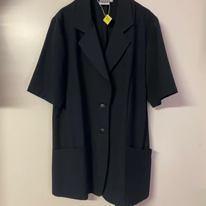 Kortärmad blazer - Kortärmad blazerliknande blus i svart, i storlek 40. Frakt tillkommer