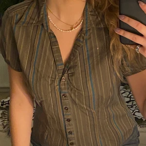 Kortärmad blus/skjorta - Säljer denna riktigt coola randiga blusen/skjorta! Personligen älskar jag tyget då det går i mer grönt/militärgrönt än vad som syns på bilderna och ränderna i blått, limegrönt och lite orange som ni ser på närbilden💚💚 Är från märket Greenhouse och är i storlek 38 och sitter som en 38:) Skriv för fler bilder eller frågor, köparen står för frakten📦📦