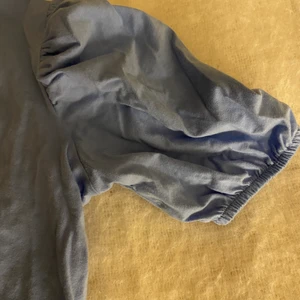 En blå t-shirt med volang ärmar - En blå t-shirt med volang ärmar säljer pågrund utav att den inte används så den är som ny 