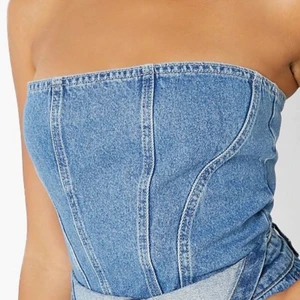 Korsettopp i jeans - Världens snyggaste topp i jeans! Helt oanvänd med prislapp kvar, köpt för 300kr. Strl 40 men passar 34-36