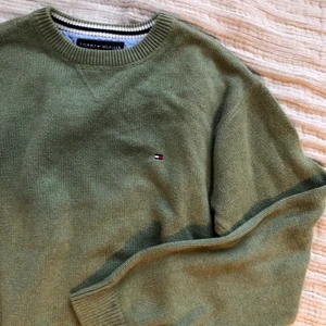 Tommy Hilfiger stickad tröja - Säljer en stickad tröja från Tommy Hilfiger i färgen grön! Storlek L men sitter som Medium. Den har haft 2 små hål i ena ärmen, som jag sytt igen (se bild 2) Annars är den i bra skick! (har köpt den second hand)  💚 Frakt tillkommer!