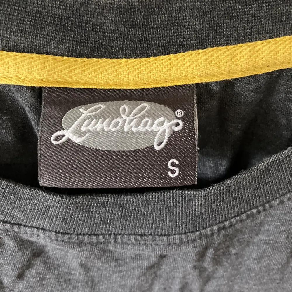 En grå t-shirt från Lundhags med gul text       I storlek S. T-shirts.