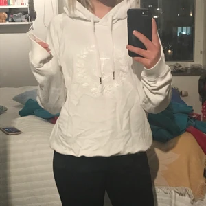 Hoodie men insytt tryck - En vit hoodie från Henri Lloyd Woman med randig luva. Det är inbeordrat tryck på framsidan och luvan är blå/vit-randig. Tröjan är i storlek ”5” men skulle säga S/M. Pris EJ inkl frakt💞