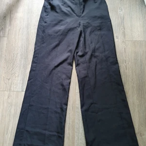 Svarta vida kostymbyxor- HM - Supersnygga svarta vida kostymbyxor från HM i stl 38. Byxorna är inte högmidjade, sitter straxt under naveln. De är dock rätt långa i benen (jag är 172 och de är lite för långa). Mer bilder vid intresse. Priset är exklusive frakt.