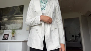 Vit kavaj - Vit kavaj med knappar på båda sidorna.