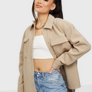 Oanvänd skjort jacka i beige. Storlek M - Skjortjacka i beige. Mjukt material på utsidan. Storlek M. Aldrig använd. 