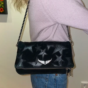 Zadig et Voltaire Väska - Säljer denna supercoola Zadig et Voltaire väskan! Den är svart med stjärnor i skinn på! Det finns en kort kedja som passar perfekt till att ha den över axeln, och en lång kedja som passar till att crossover! Har även dustbagen kvar!💗Den är i använt men bra skick och jag köpte den för 3600 kr och säljer för 2800!🙌🏼💗Kontakta vid intresse!