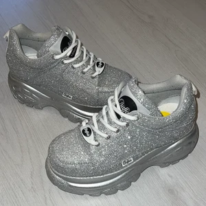 Buffalo London  - SUPERFINA Buffalo London, glittriga i silver, storlek 36 (rätt stor i storleken men har fungerat på mig som är normal 36 med extra sula) Använda endast en gång och då under ungefär 1,5h så i stort sett helt oanvända! 