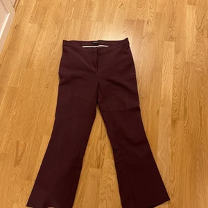 Tiger of sweden kostymbyxor - Kostymbyxor som är i så gott som nyskick. Vinröda åt det lila hållet. Sitter tight ner till knäna där de går ut lite som ett par bootcuts, slutar vid anklarna ungefär