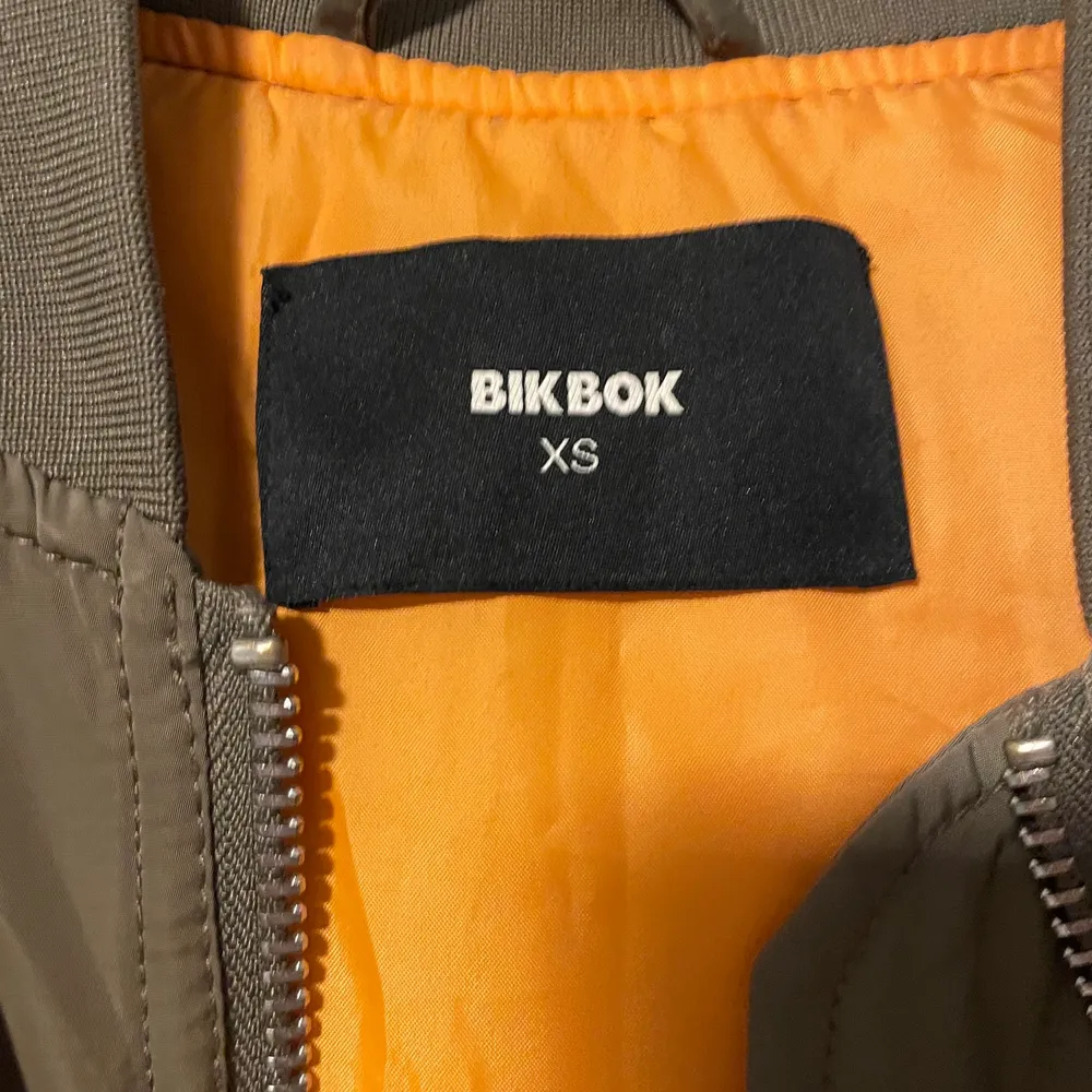 Militärgrön bomberjacka med orange insida. Finns en ficka på vänster ärm och är i storlek xs. Den är i fint skick 🤗. Jackor.