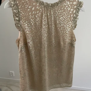 Guldig Topp  - Jättefin topp från oasis! Använd en gång! Passar jättebra till sommaren! Köpt för ca 500kr