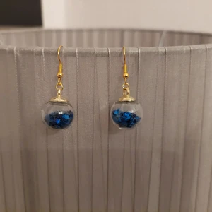 Örhängen  - Örhängen. Plastkulor fylla med blå paljettstjärnor. 