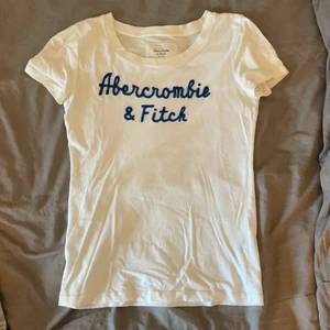 T-shirt - Säljer denna fina t-shirt från abercrombie & fitch då den inte kommer till användning. Den börjar bli lite nopprig (se bild 2) och där är även ett litet litet hål under ena armen (se bild 3). Detta är dock inget som stör enligt mig